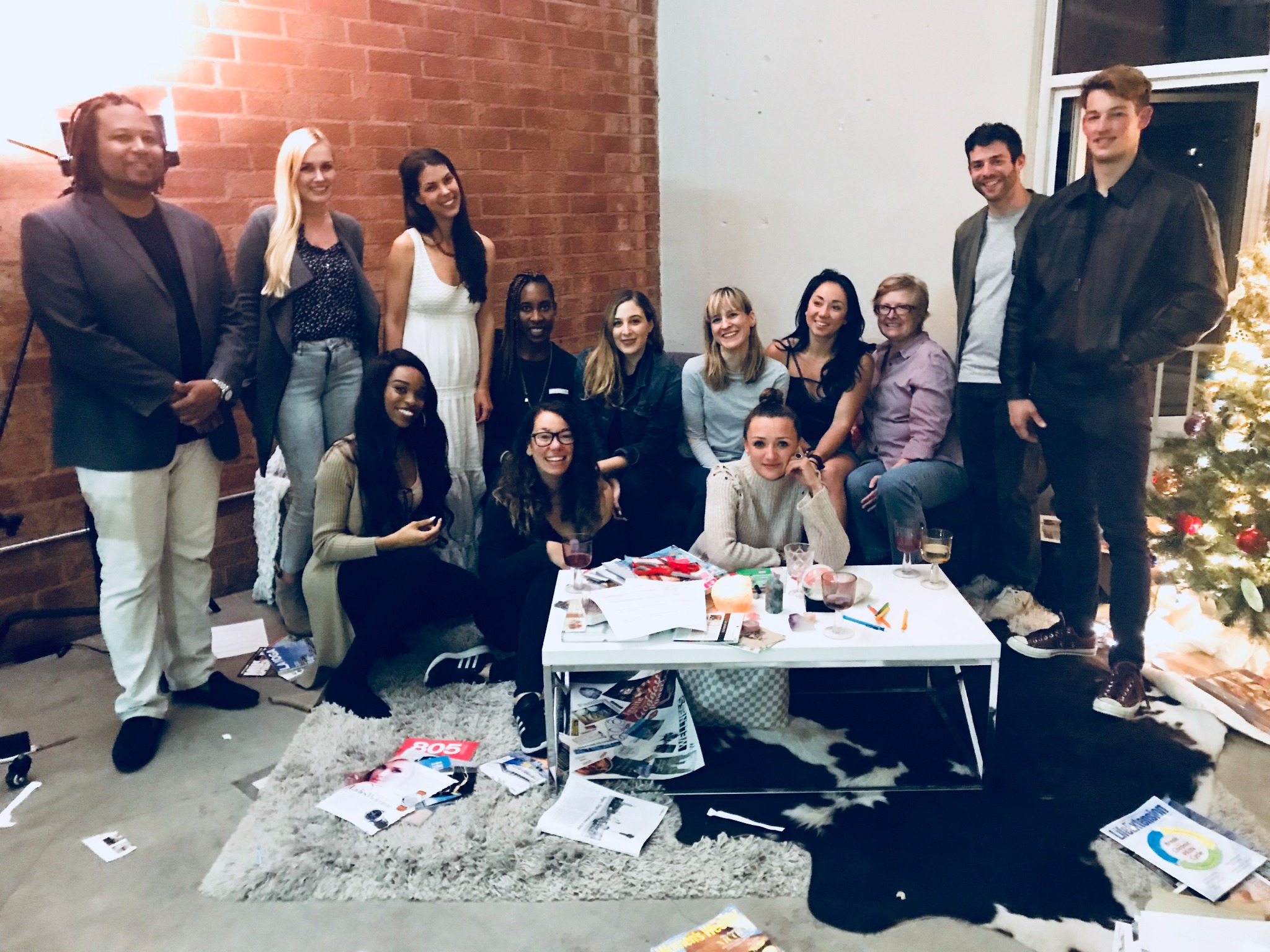 A group gathered around a table with magazines, paper, and creative materials