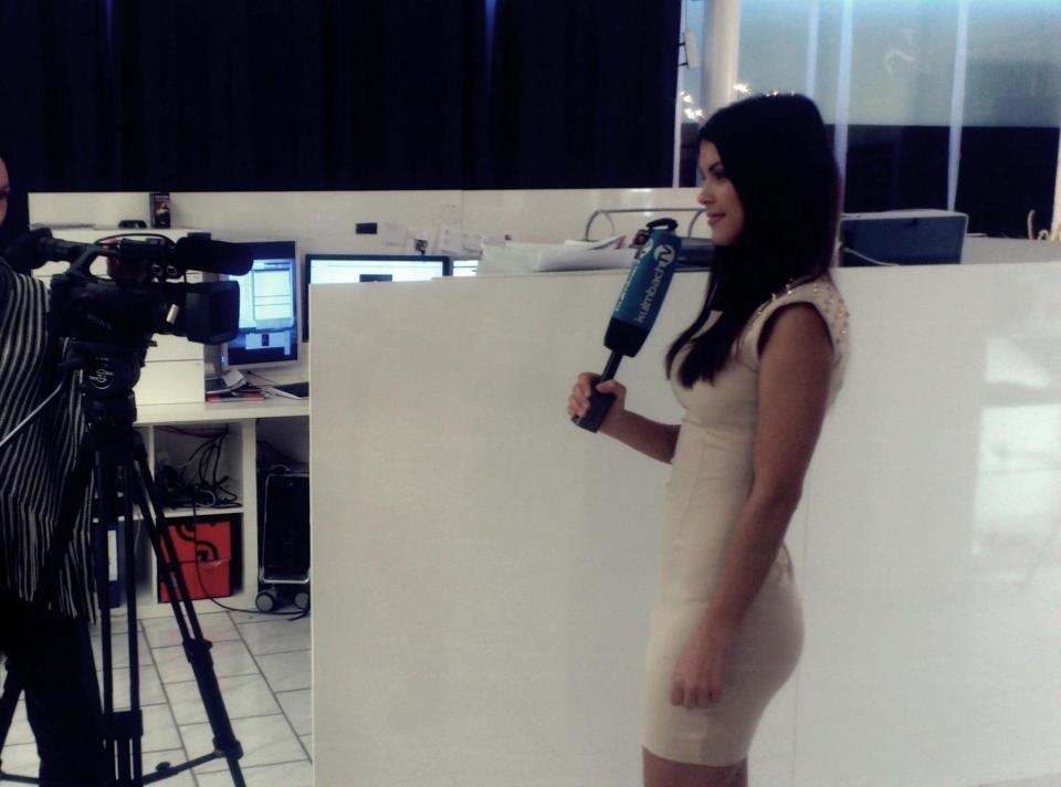 Sarah holding a microphone in front of a video camera