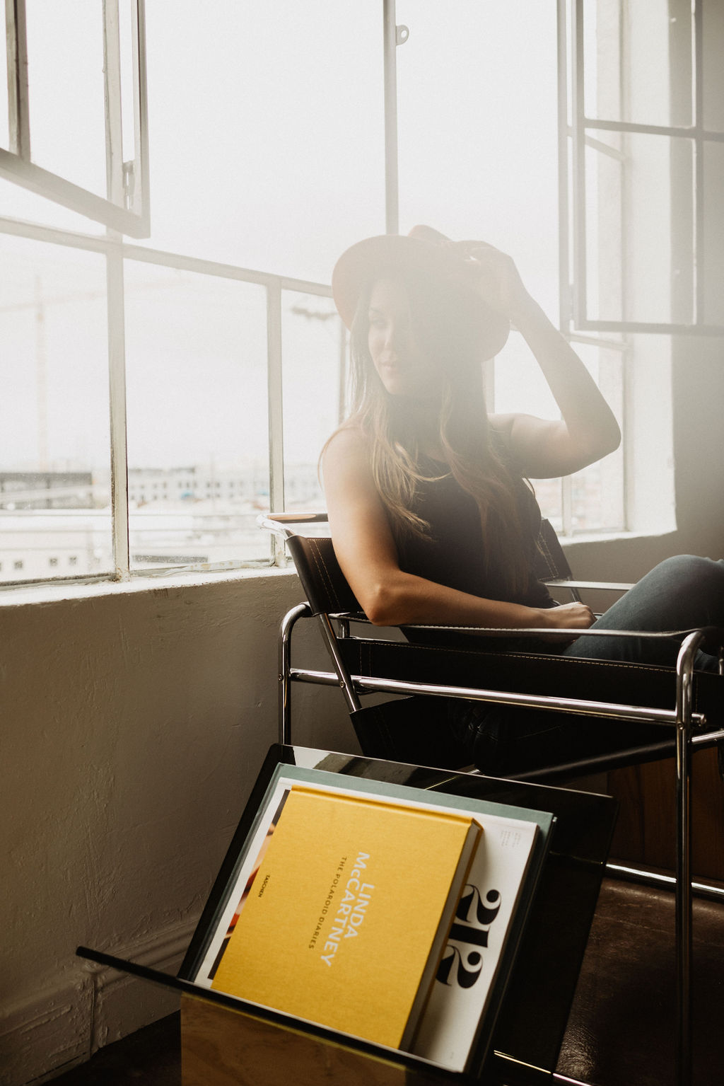 Sarah seated by a sunlit studio window