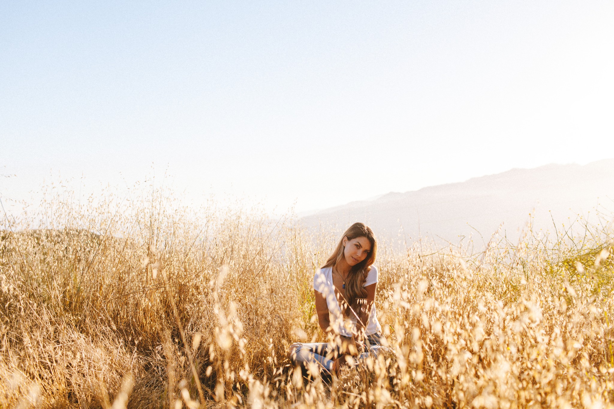 Sarah sitting in a sunlit meadow