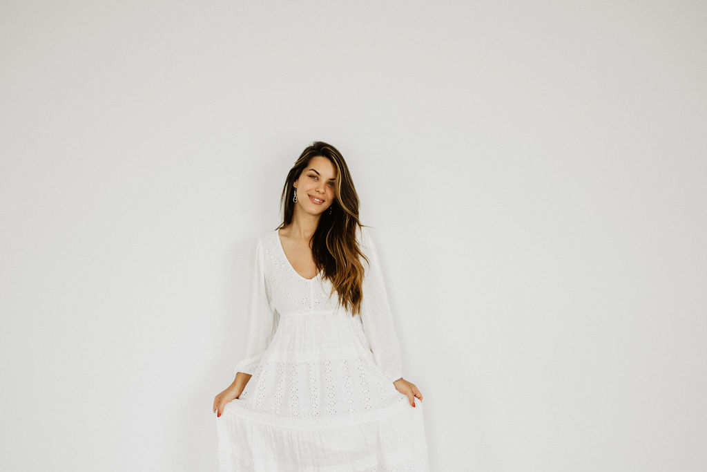 Sarah smiling in a white dress